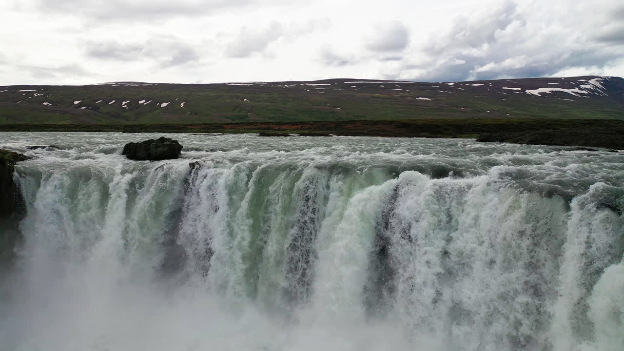 drone volando sobre la cresta de la cascada godafoss en el norte de islandia en un día nublado - antena baja
