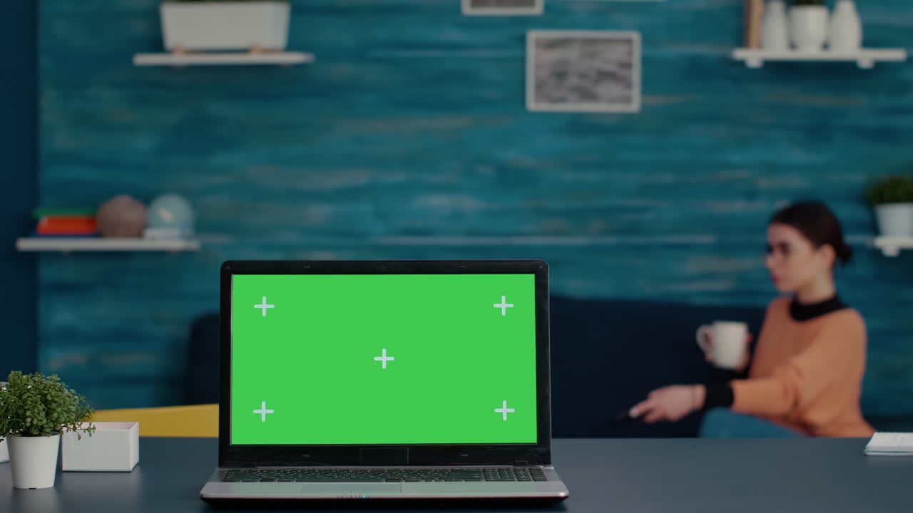 Modern laptop with green screen template on desk at home