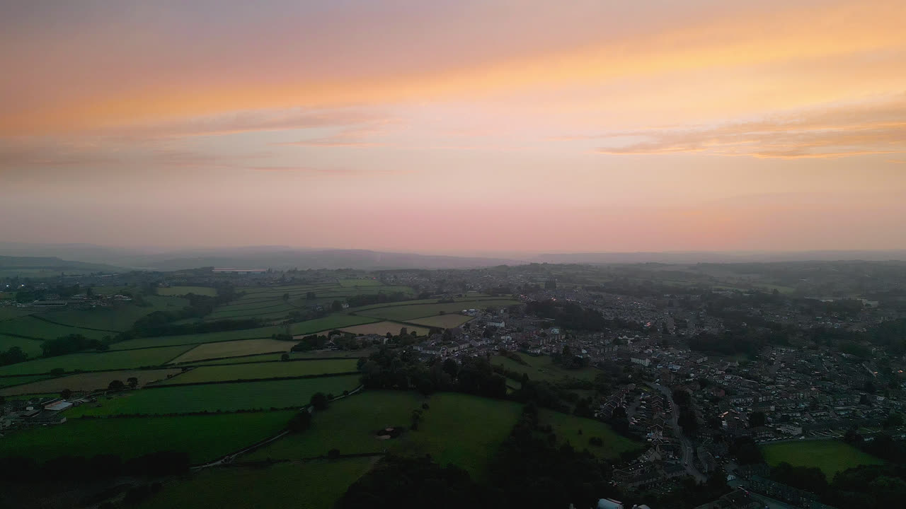 영국 헤크몬드와이크 를 체험 하십시오. 드론 으로 촬영 된 매혹적 인 공중 영상 을 통해, 여름 저녁 에 산업 구조물, 활기찬 거리, 그리고 역사적 인 도시 중심지 를 강조 합니다.