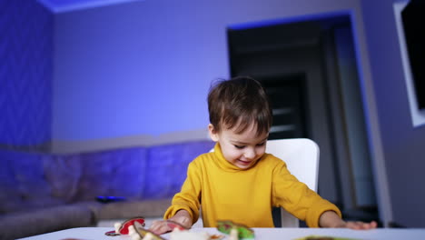 cute baby runs up to his desk cheerfully. lovely toddler drops a puzzle piece and goes down to find it.