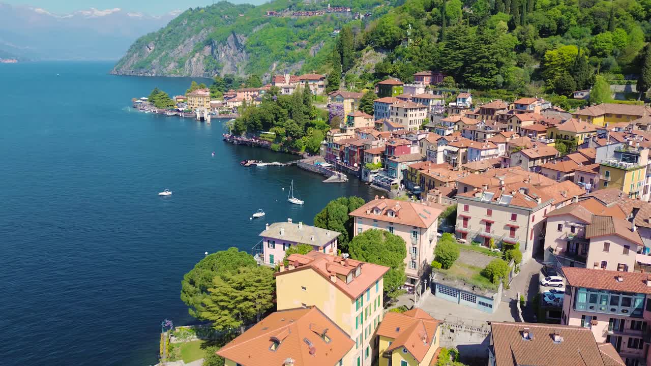 Vista aerea con drone delle case colorate di Varenna sulla costa del Lago di Como, pittoresco villaggio italiano sull'acqua, destinazione di viaggio Italia