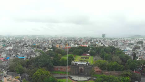 Dolly-Back-Drohnenaufnahme-über-Shaniwar-Wada-Verkehr-Auf-Der-Chhatrapati-Shivaji-Brückenstraße-Dr.-Hegdwar-Chowk-Old-Pune-City-Heritage-Site-Indien