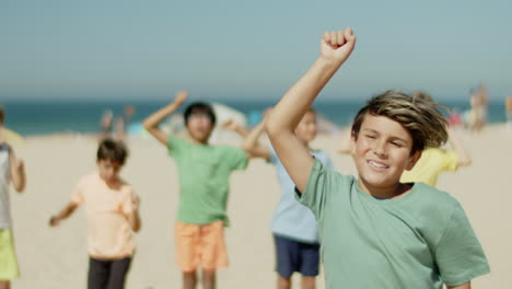 medium shot of soccer player leaping for joy on sandy beach