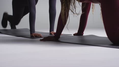 disparo de estudio de cerca de dos mujeres vestidas con ropa de gimnasia frente a frente haciendo ejercicio