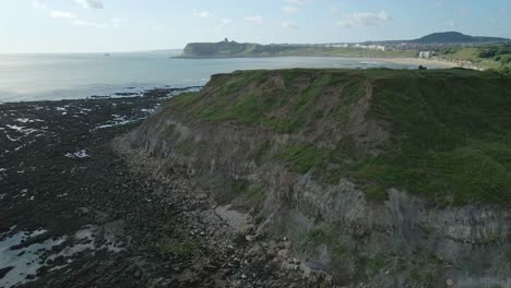 Aerial-view-of-North-bay,-Scarborough,-North-Yorkshire-with-cliffs,-coastline,-ocean,-and-castle