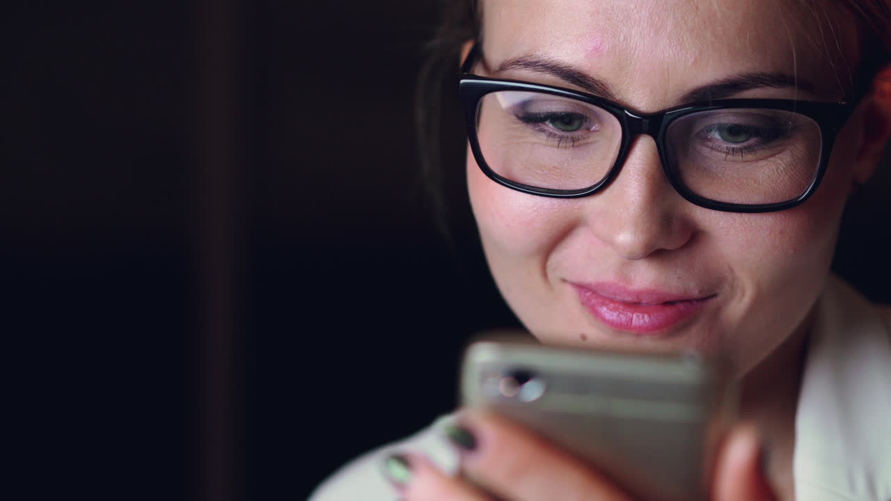mujer usando teléfono móvil por la noche