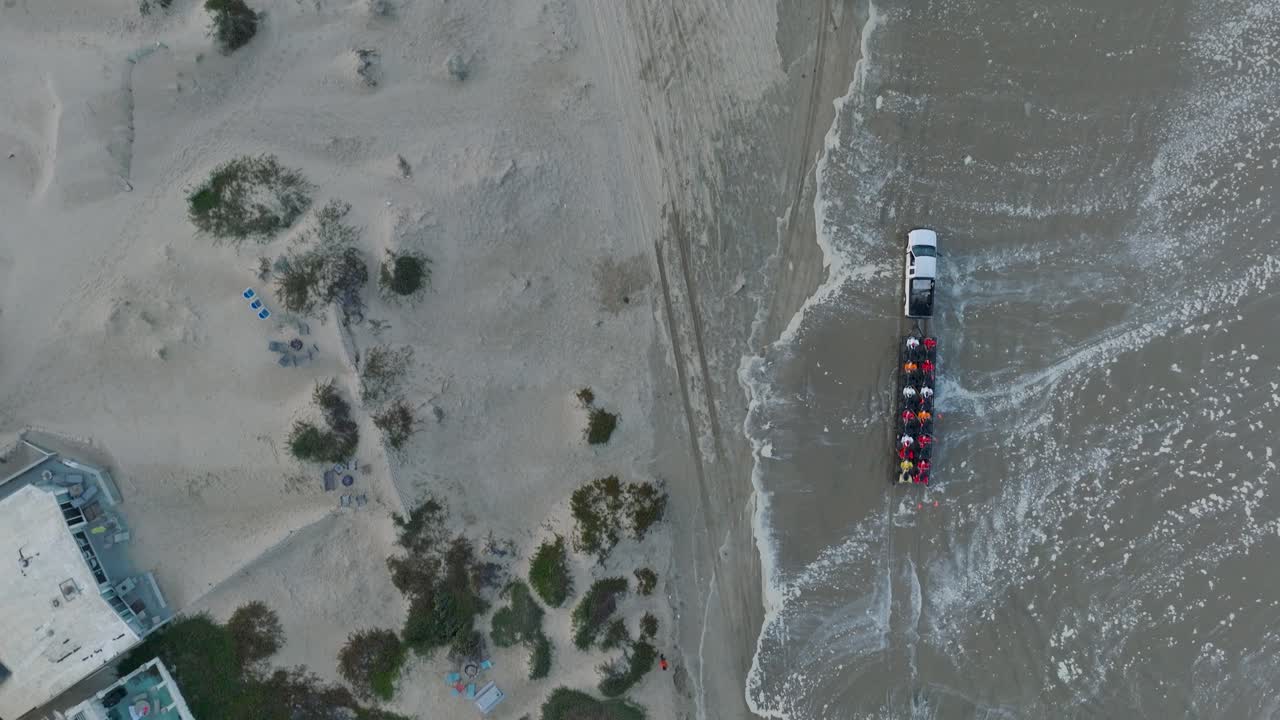 Aerial Top Down Drone shot of Truck with Trailer and ATV's Driving on Pismo Beach California Sand Beach at Sunrise
