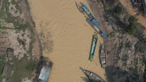 birds eye view over muddy river im cambodia with boat traffic on tonle sap