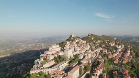 San-Marino,-Italy,-city-on-a-mountain,-city-building,-drone-pull-out-view