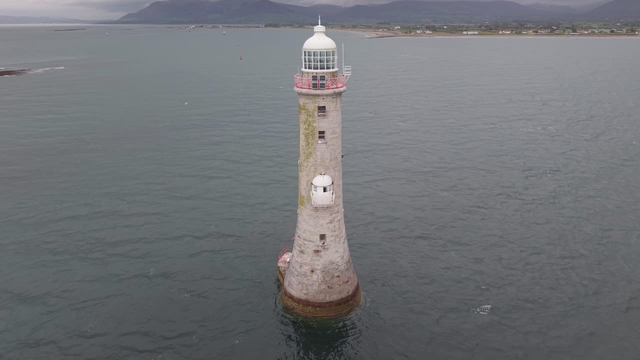 Lighthouse stands tall in the sea near County Down, serene and classic feel