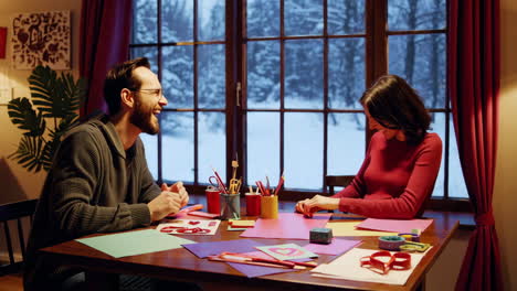 couple crafting valentine's day cards by the window