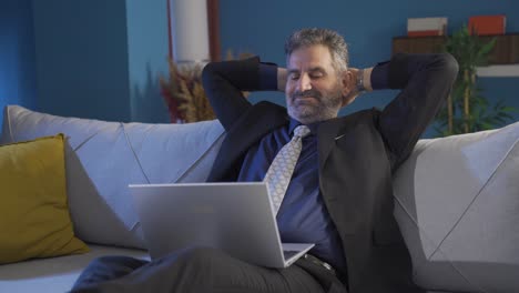 relaxed businessman takes a break to relieve stress. satisfied happy mature businessman sitting on sofa at home and resting.