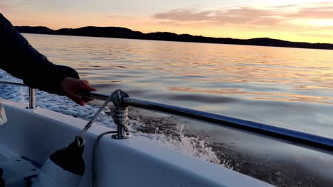 driving with a small boat on a fjord in norway at sunset