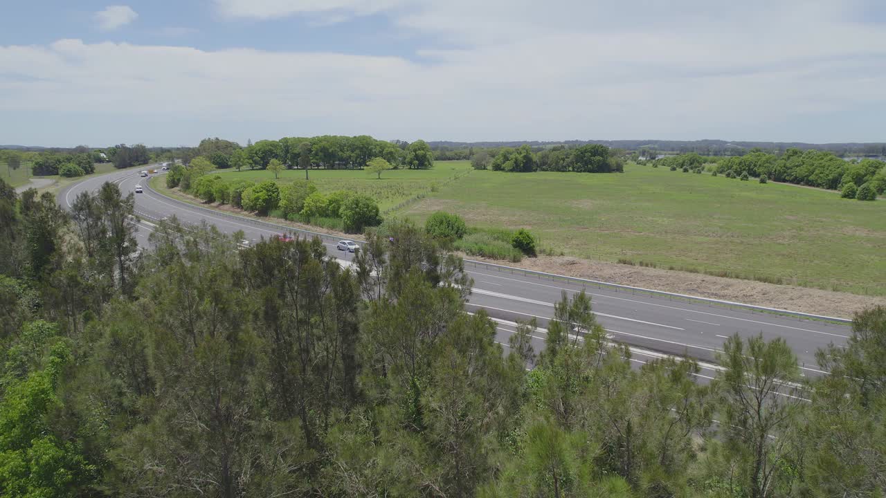 호주 뉴사우스웨일즈 중북부 해안 지역의 무성한 푸른 나무 뒤에 드러난 맥클레이 계곡 길과 범람원