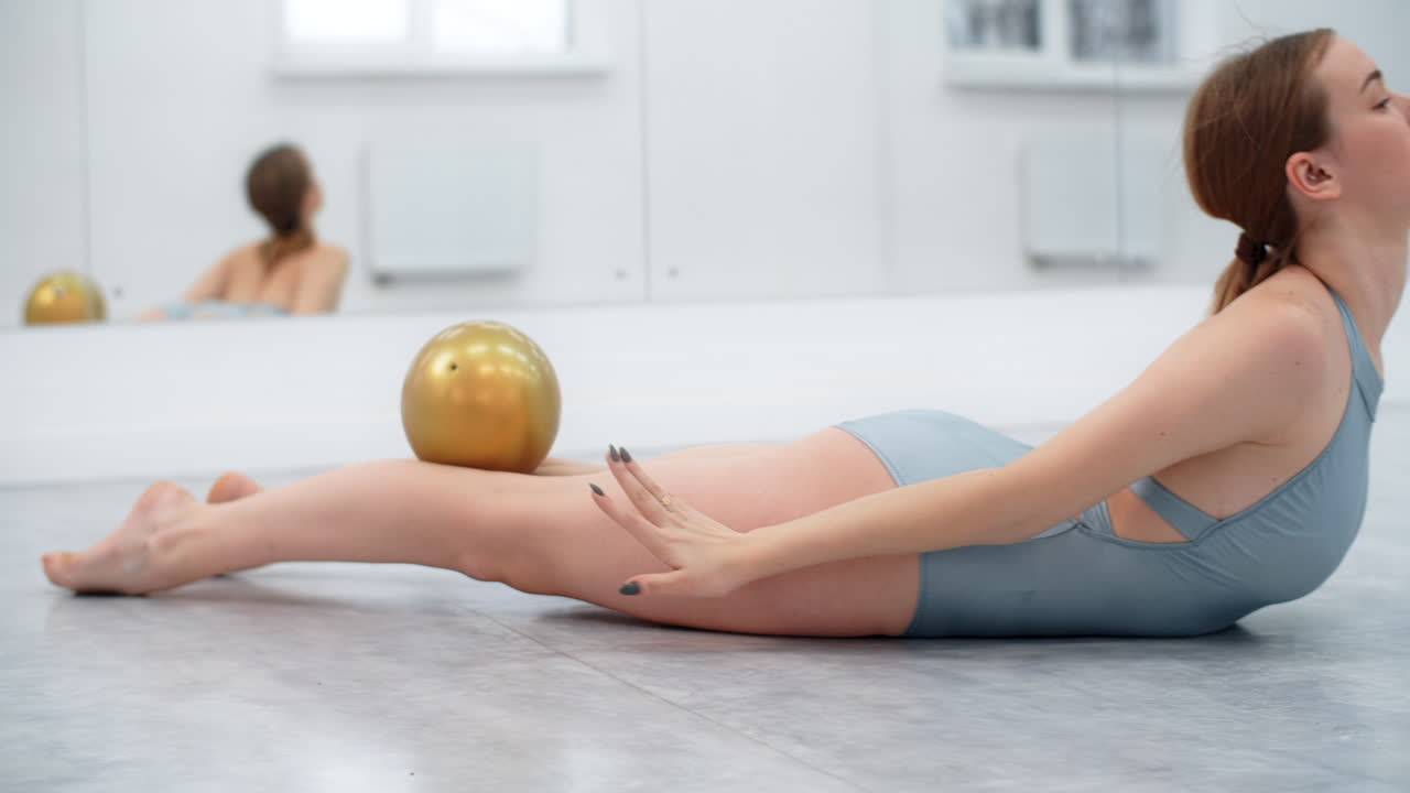 Woman performing ballet exercises with ball