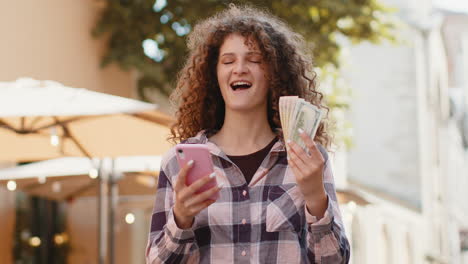 mujer feliz con dinero en efectivo y celebrando el éxito