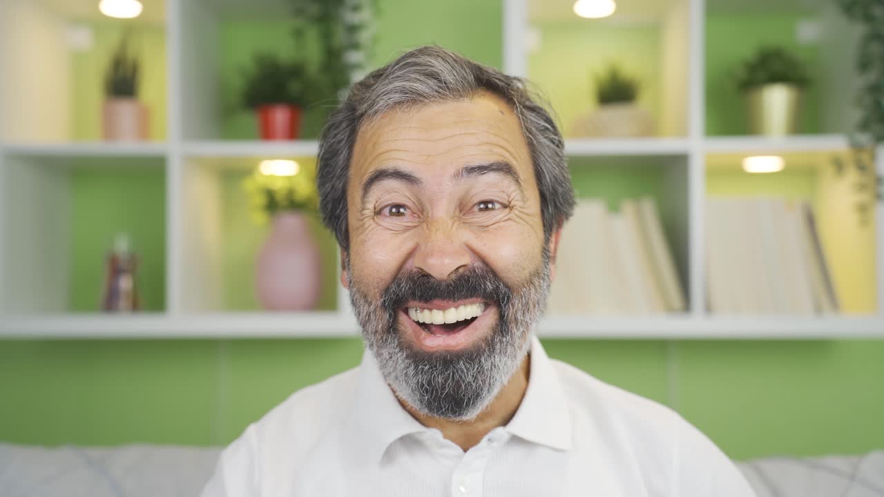 hombre maduro en primer plano mirando a la cámara regocijándose y satisfecho.
