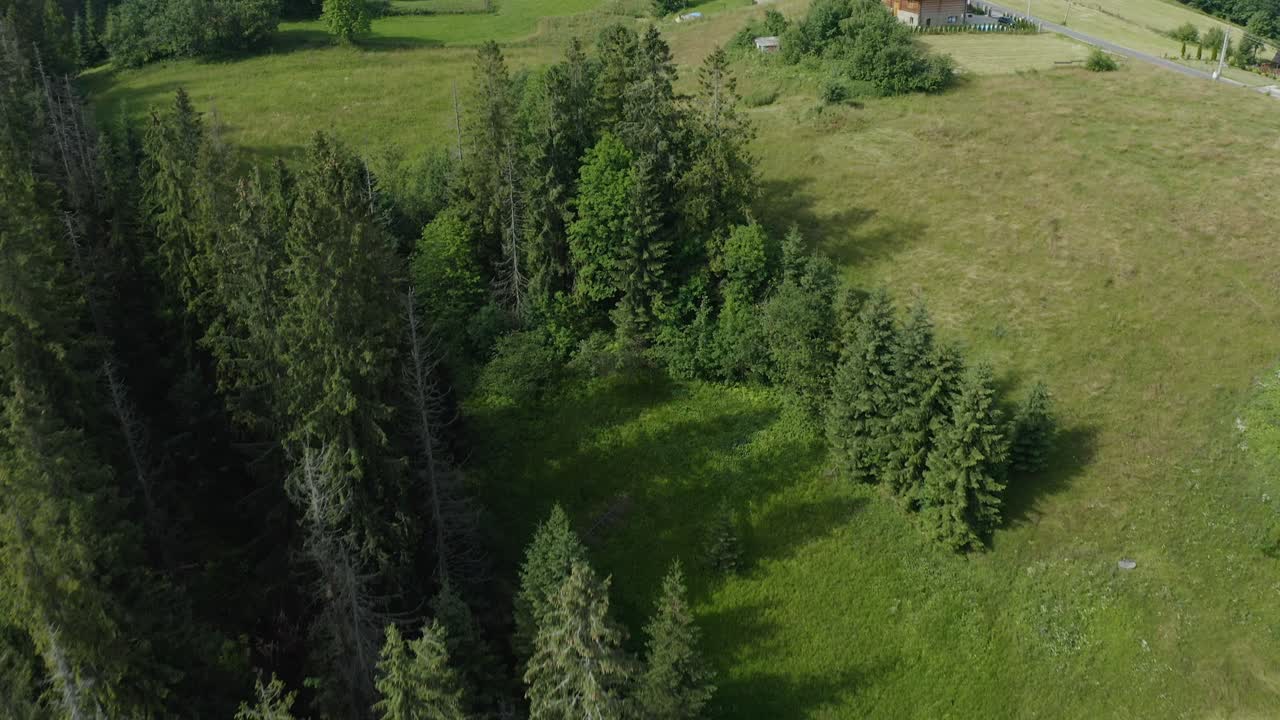 дрон спускается с вершины на традиционные деревенские дома с альпийскими горами на заднем плане