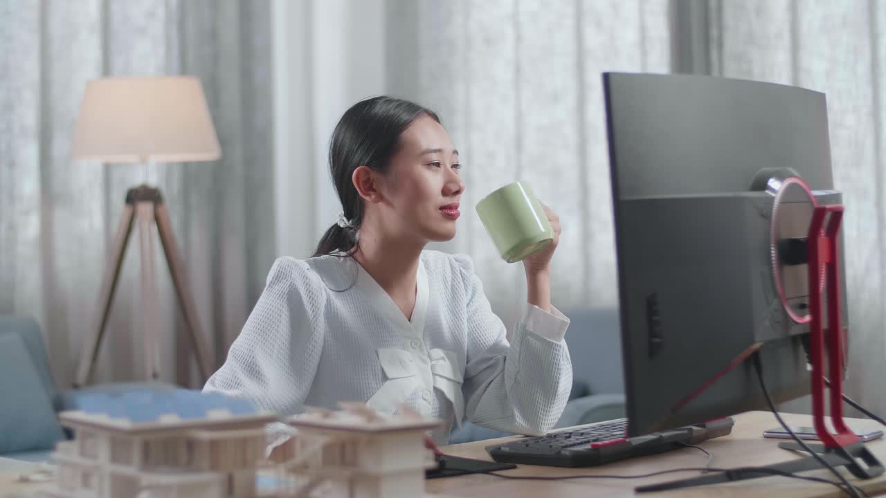 집에서 데스크에서 일하면서 커피를 마시는 하우스 모델과 함께 아시아 여성 엔지니어