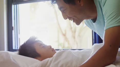 Man-kissing-his-son-while-sleeping-on-bed-4k