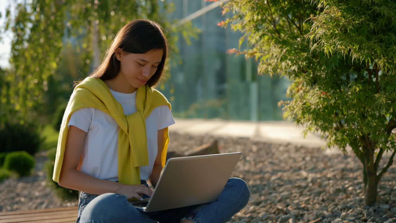야외에서 노트북으로 일하는 젊은 여성