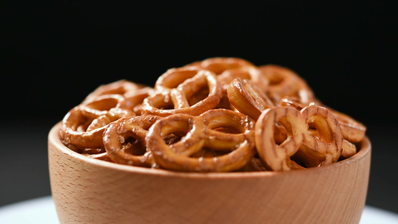 Ciotola rotante di pretzel su tavolo, primo piano, concetto di snack