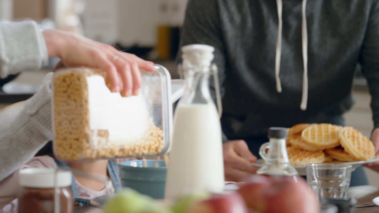 행복 한 가족 이 함께 아침 식사를 하고 있는 부모 들 은 집 에서 주방 에서 자녀 들 을 위해 시리얼 을 준비 하고 있다