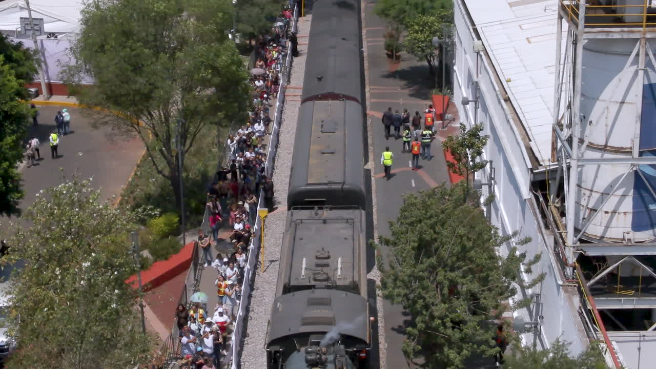 Steam Train Arriving at Station with Large Crowd of Spectators