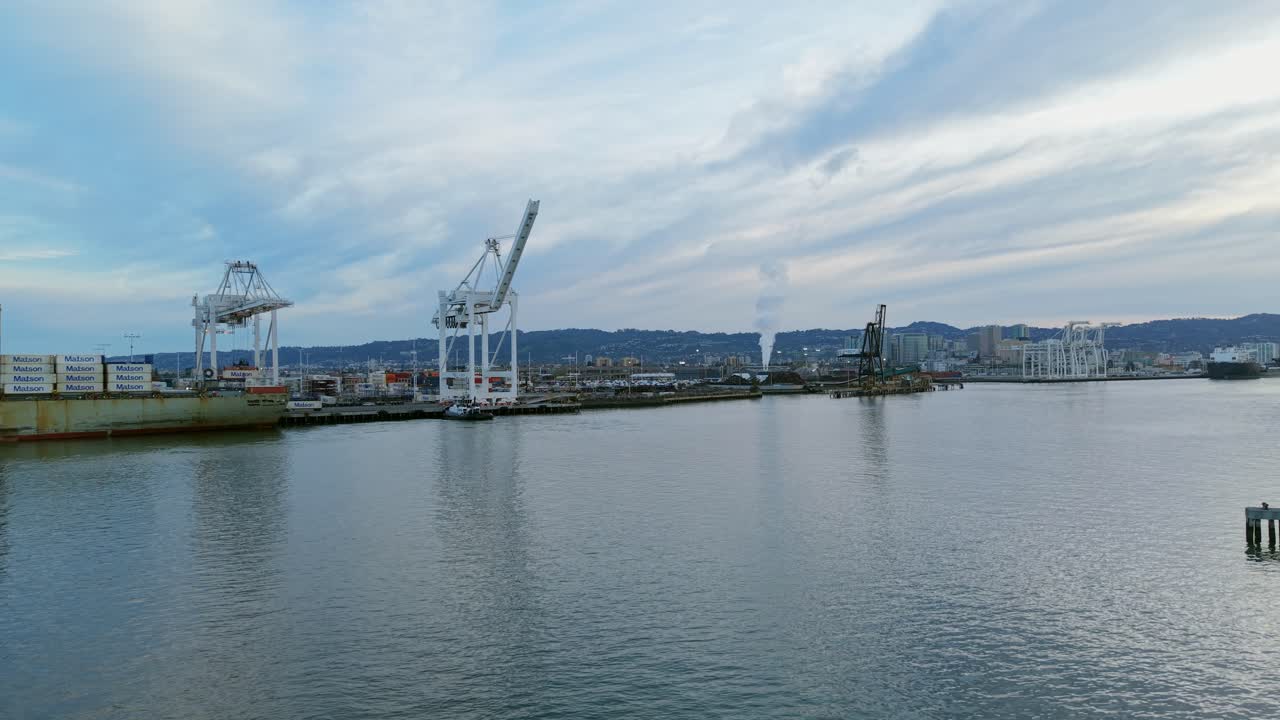 Ascending drone view of the cranes along the Port of Oakland.