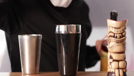 Bartender-Pouring-Cocktail-Into-A-Bartending-Tumble-With-A-Cocktail-Shaker-On-The-Bar-Counter---close-up,-slow-motion