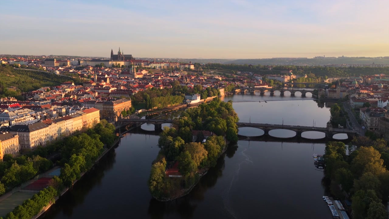 Korkealta otettu ilmakuva Vltava-joesta, jossa Kaarlensilta ja Prahan linna näkyvät kukkulalla aamuvalossa, Strelecky ostrov -saari etualalla, Praha, Tšekin tasavalta.