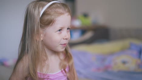 mother gives medicine to cute girl with spoon on bed