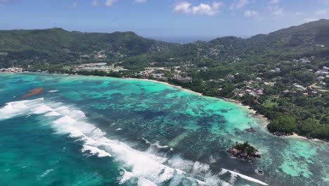 aerial view of a tropical coastline with turquoise ocean and lush mountains