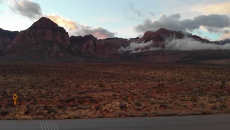 Aerial drone shot of an empty road with mountains in the background