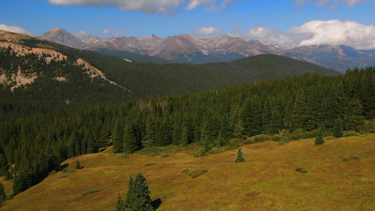 Colorful Colorado cinematic aerial drone summer Boreas Pass Breckenridge Summit County windy green grass dramatic incredible landscape Rocky Mountain peaks daylight backwards reveal up motion
