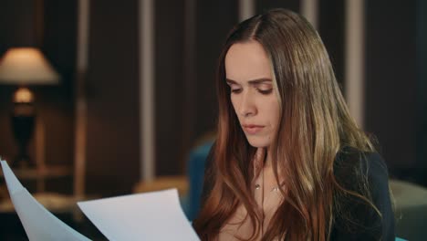 serious businesswoman reading paper documents in office