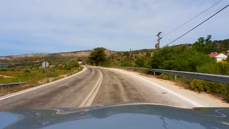 Slow-Drive-Up-A-Mountain-Road,-Driver-POV,-Thassos,-Greece,-Clear-Blue-Sky,-Mediterranean-Sea