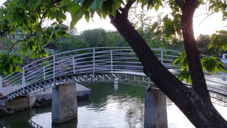 Schöne-Weiße-Gewölbte-Fußgängerbrücke-über-Einen-Kleinen-Fluss-Im-Medicine-Park-Oklahoma