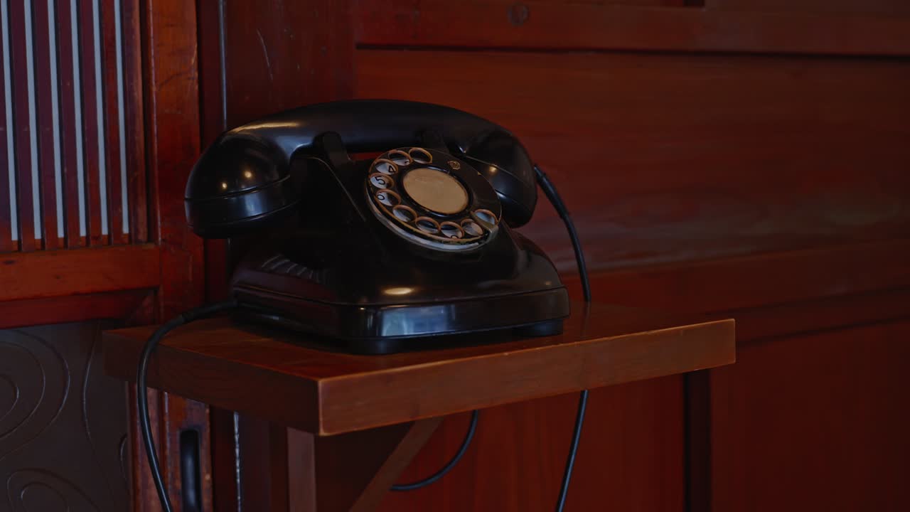 Sebuah bidikan stabil telepon putar hitam klasik tahun 1950-an-60an di dalam bangunan kayu tradisional di Museum Arsitektur Terbuka Edo-Tokyo.