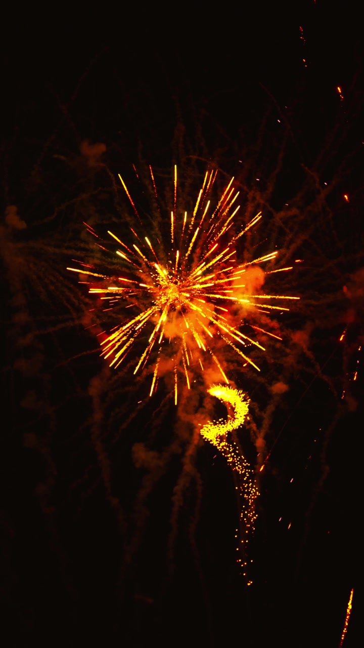 Spettacolo di fuochi d'artificio dorati e vivaci che esplode nel cielo notturno