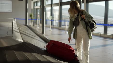 Mujer-Viajera-Esperando-En-El-Aeropuerto-Junto-Al-Equipaje,-Revise-El-Caso-En-Las-Cintas-Transportadoras