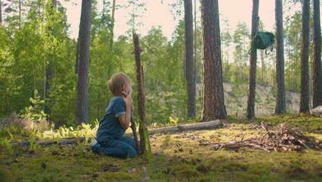 Two-little-boy-collecting-firewood-in-the-forest.-Two-little-brothers-in-the-forest-gather-wood-together-and-build-a-fire