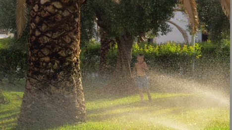 Kind-Läuft-Auf-Dem-Rasen-Und-Wird-Von-Der-Wassersprinkleranlage-Nass