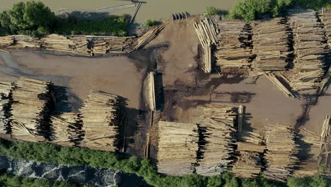 Cinematic-top-down-shot-of-tree-trunk-piles-at-a-lumber-yard-logging-site-in-the-United-State