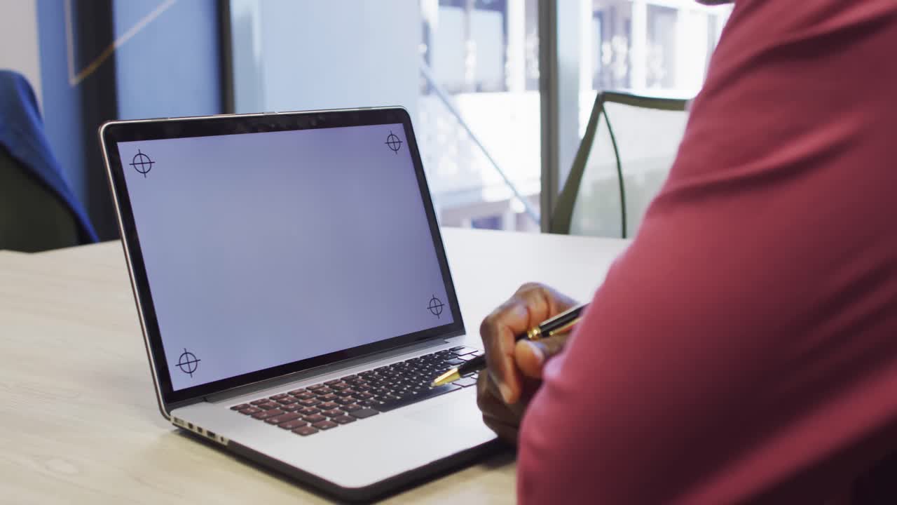 Video of african american man working on laptop with copy space on screen