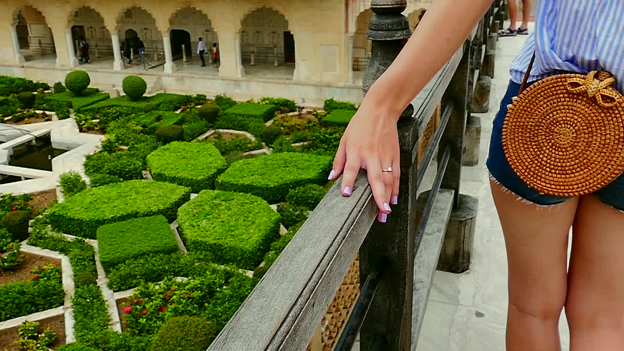 Young girl with ring touching the wooden fence over the inner courtyard in slow motion
