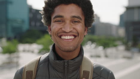 portrait of handsome young mixed race man laughing cheerful at camera enjoying sunny urban city commuting travel