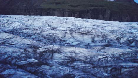 Vista-Aérea:-Sobrevuelo-Circular-De-Glaciares-Con-Un-Camino-Serpenteante-Con-Profundas-Grietas-Y-Formaciones-De-Hielo-Irregulares,-Evidencia-Del-Impacto-Del-Cambio-Climático-En-El-Constante-Movimiento-Y-Transformación-De-Esta-Maravilla-Natural.