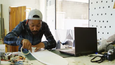 man sticking sellotape on skateboard 4k
