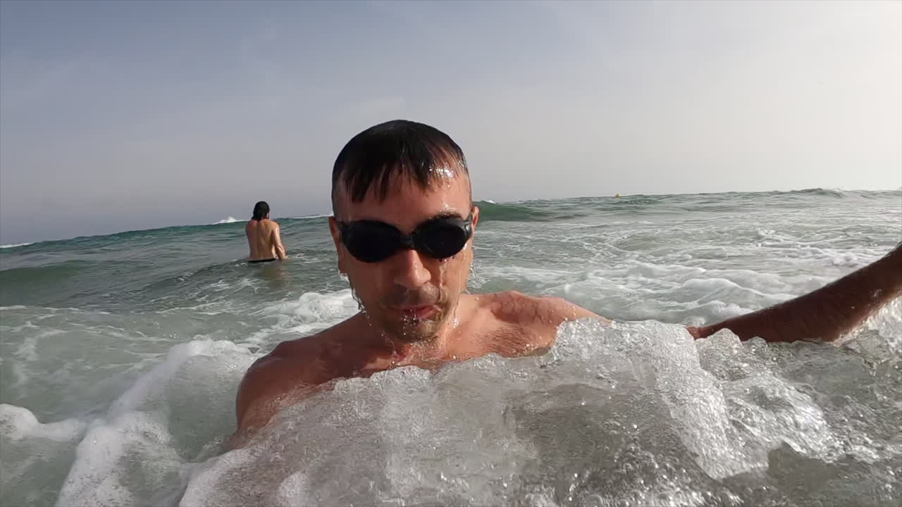 Man wearing swimming googles diving in the sea